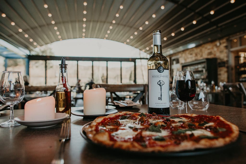Roberto Forzoni at the Mount Vineyard, close up image of a pizza and wine bottle