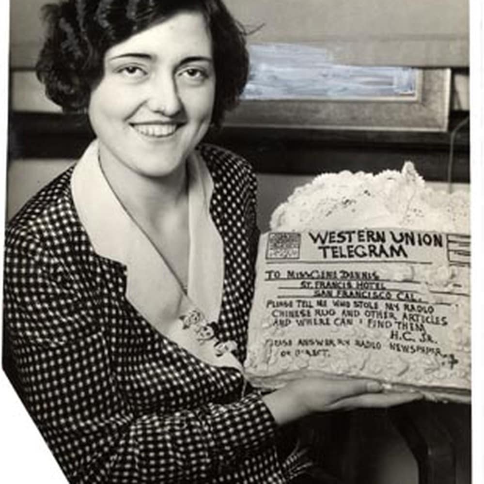Gene Dennis holding a cake iced as a Western Union telegram